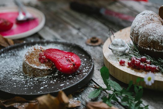 Gâteau fondant au chocolat et poire, décoré de fruits rouges et de sucre glace sur une table en bois.