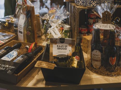 Sélection de produits d'épicerie fine, incluant vins, confitures et cadeaux artisanaux sur une table en bois.